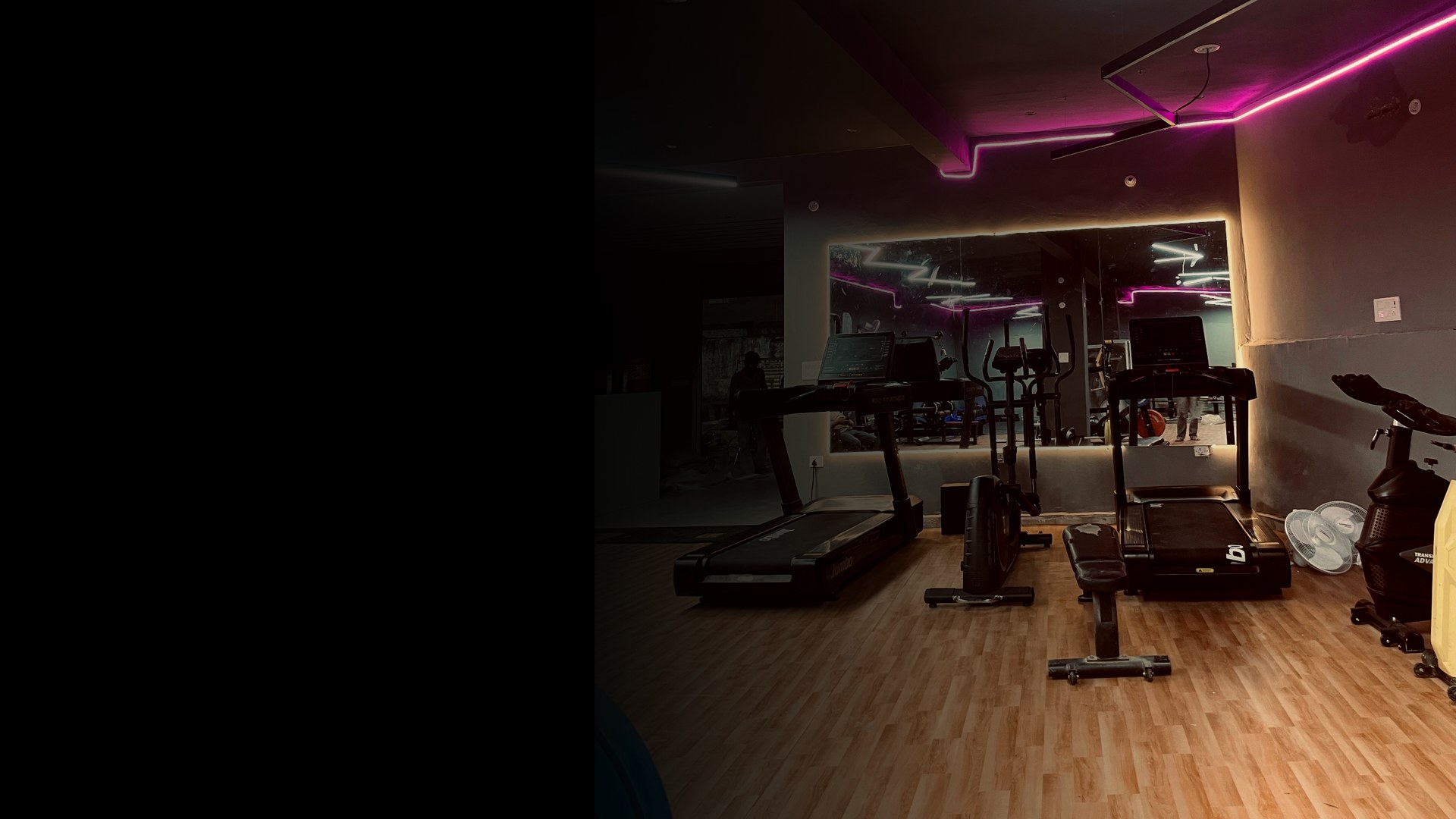 DreamFit gym floor in Manoharpur, Shahpura — treadmills, cardio machines and illuminated mirror under magenta LED lighting